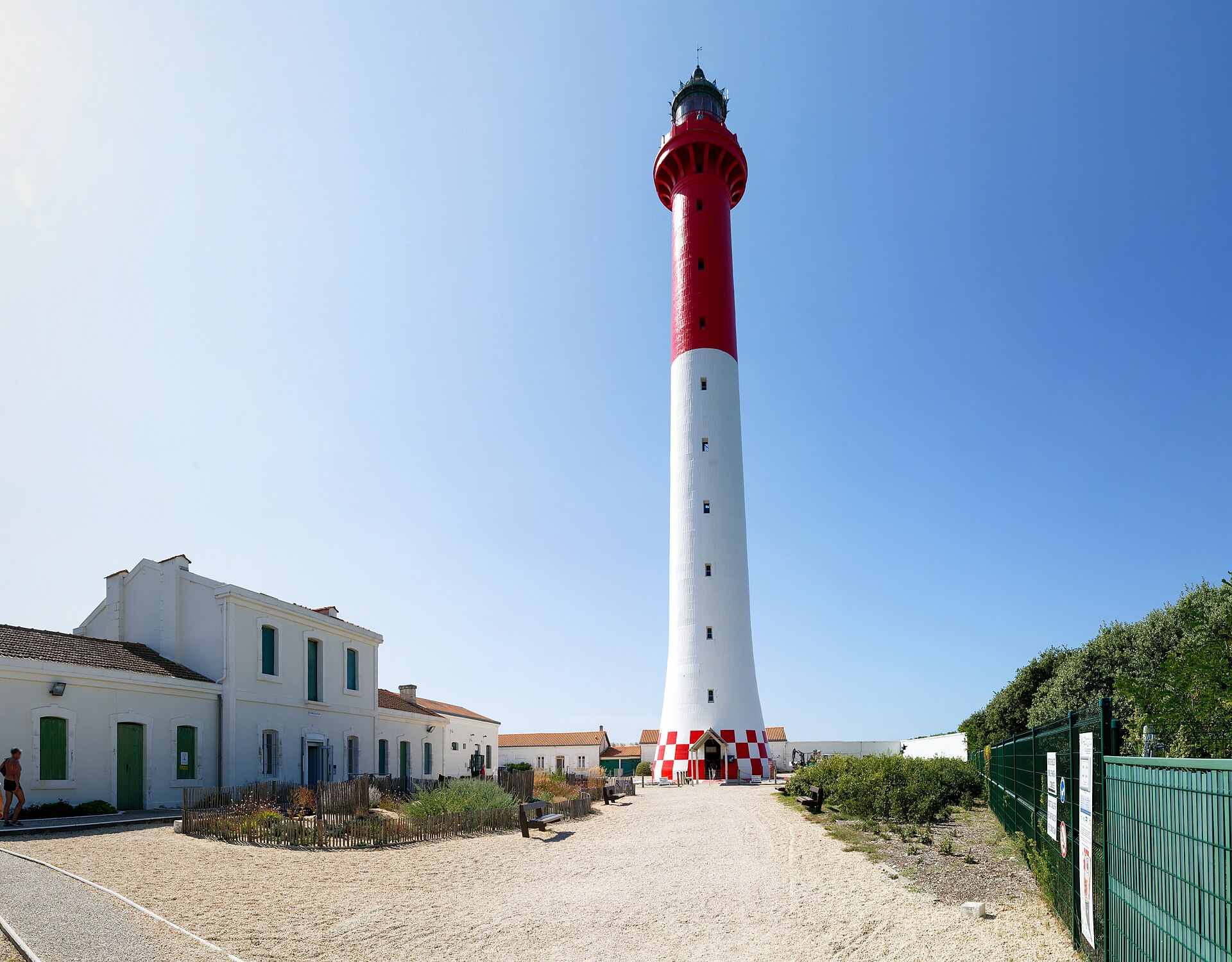 The red and white La Coubre Lighthouse standing behind the dunes of Charente-Maritime.